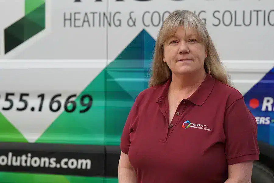 Trusted Heating & Cooling Solutions tech in front of service truck in Ann Arbor, MI.