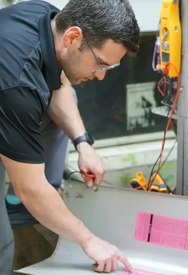 Tech repairing HVAC system in Ann Arbor, MI.